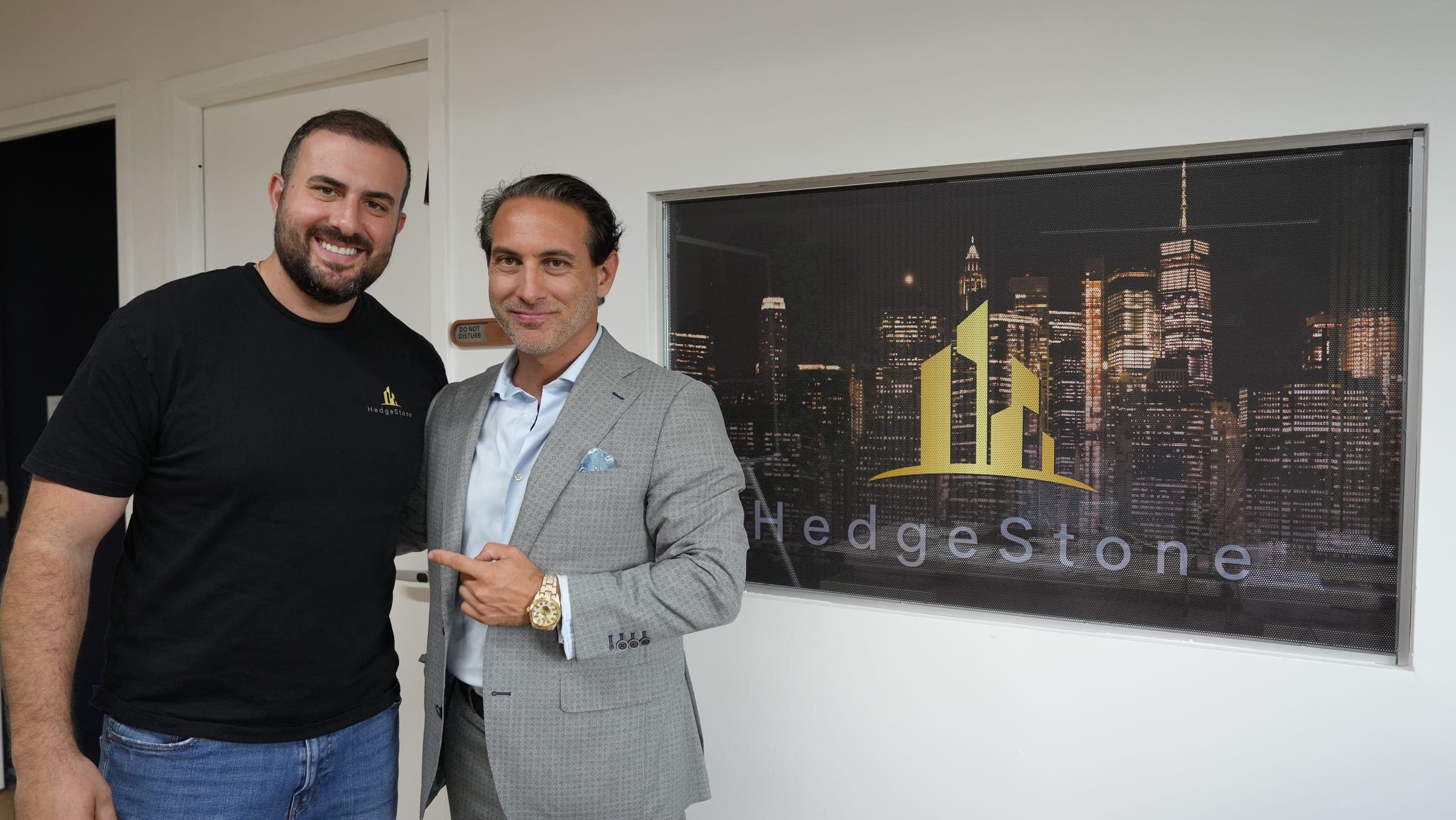 Michael Steinberg, left, and Josh Aryeh, right, pointing to a lit HedgeStone sign